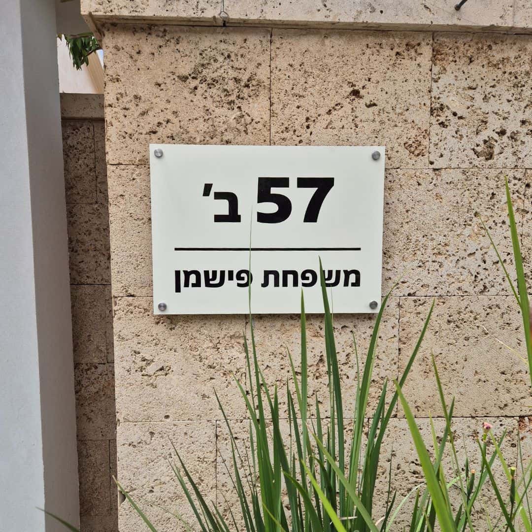 שלט כניסה לבית פרטי הכולל שם משפחה ומספר בית